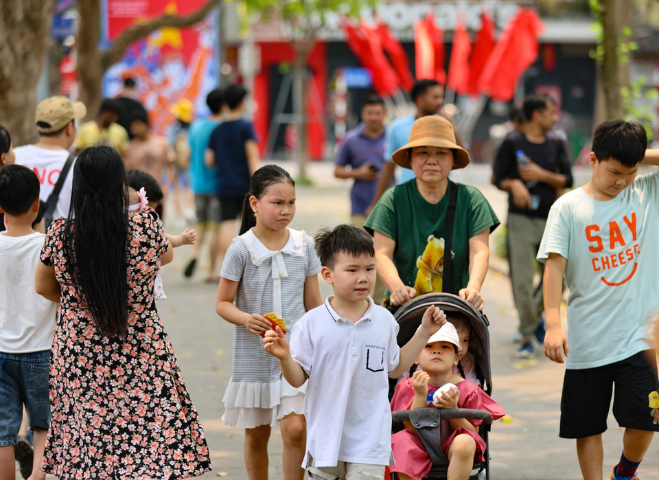 Dù nắng nóng nhưng người dân và du khách vẫn dạo bước, ngắm cảnh bên hồ. (Ảnh: Thanh Tùng/TTXVN)