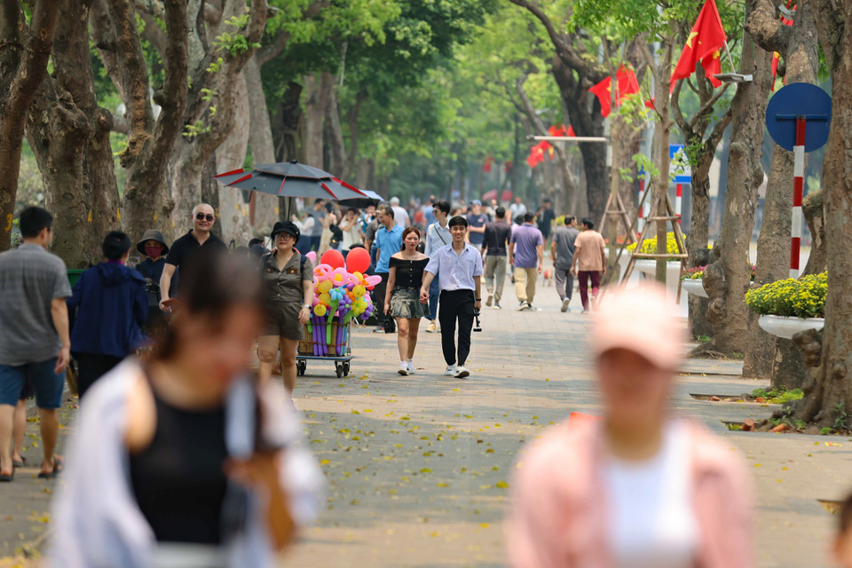 Dù nắng nóng nhưng người dân và du khách vẫn dạo bước, ngắm cảnh bên hồ. (Ảnh: Thanh Tùng/TTXVN)