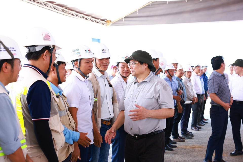 Thủ tướng Phạm Minh Chính với kỹ sư, công nhân thi công Dự án Đường bộ Cao tốc Khánh Hòa-Buôn Ma Thuột giai đoạn 1. (Ảnh: Dương Giang/TTXVN)