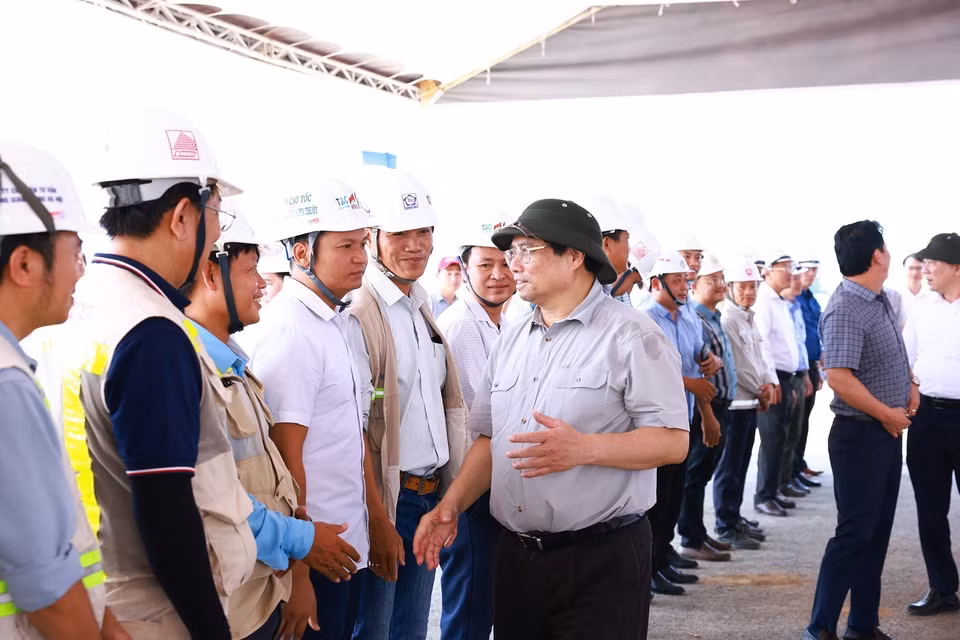 Thủ tướng Phạm Minh Chính với kỹ sư, công nhân thi công Dự án Đường bộ Cao tốc Khánh Hòa-Buôn Ma Thuột giai đoạn 1. (Ảnh: Dương Giang/TTXVN)