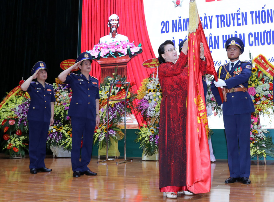 Chủ tịch Quốc hội Nguyễn Thị Kim Ngân gắn Huân chương Quân công hạng Ba lên lá cờ truyền thống của lực lượng Cảnh sát biển Việt Nam. (Ảnh: Trọng Đức/TTXVN)
