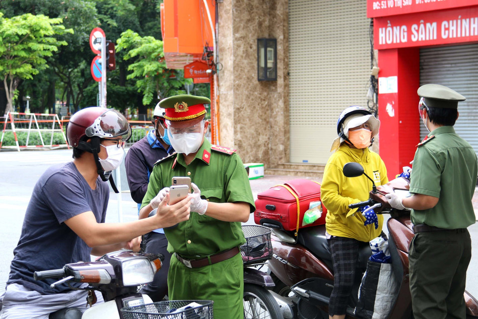 Lực lượng chức năng kiểm tra người dân thực hiện khai báo thông tin di biến động trên đường Võ Thị Sáu, quận 3, Thành phố Hồ Chí Minh. (Ảnh: Thanh Vũ/TTXVN)
