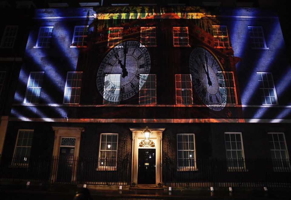 Hình ảnh đồng hồ Big Ben, biểu tượng của Anh, được chiếu sáng trên bức tường tòa nhà số 10 phố Downing, London với thời khắc 23 giờ tối 31/1/2020, thời điểm Anh chính thức rời Liên minh châu Âu (EU). (Ảnh: THX/TTXVN)