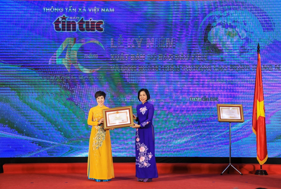Tổng Giám đốc TTXVN Vũ Việt Trang trao Bằng khen của Thủ tướng Chính phủ cho Tổng Biên tập Báo Tin tức Ninh Hồng Nga. (Ảnh: Tuấn Anh/TTXVN)