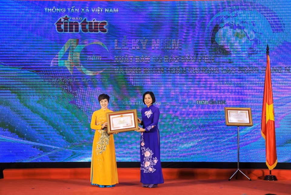 Tổng Giám đốc TTXVN Vũ Việt Trang trao Bằng khen của Thủ tướng Chính phủ cho Tổng Biên tập Báo Tin tức Ninh Hồng Nga. (Ảnh: Tuấn Anh/TTXVN)