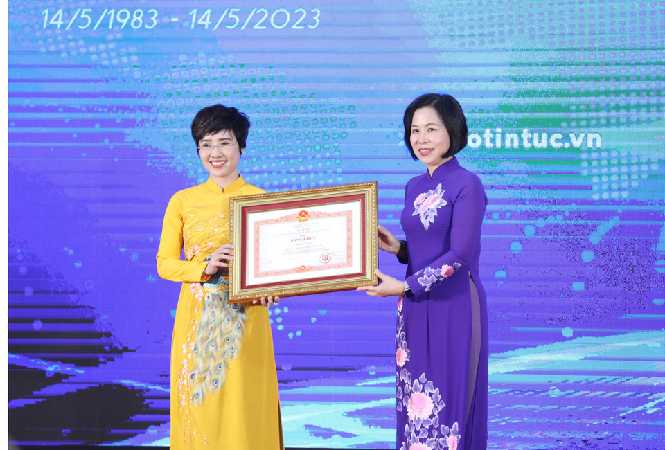 Tổng Giám đốc TTXVN Vũ Việt Trang trao Bằng khen của Thủ tướng Chính phủ cho bà Ninh Hồng Nga, Tổng biên tập Báo Tin tức. (Ảnh: Tuấn Anh/TTXVN)