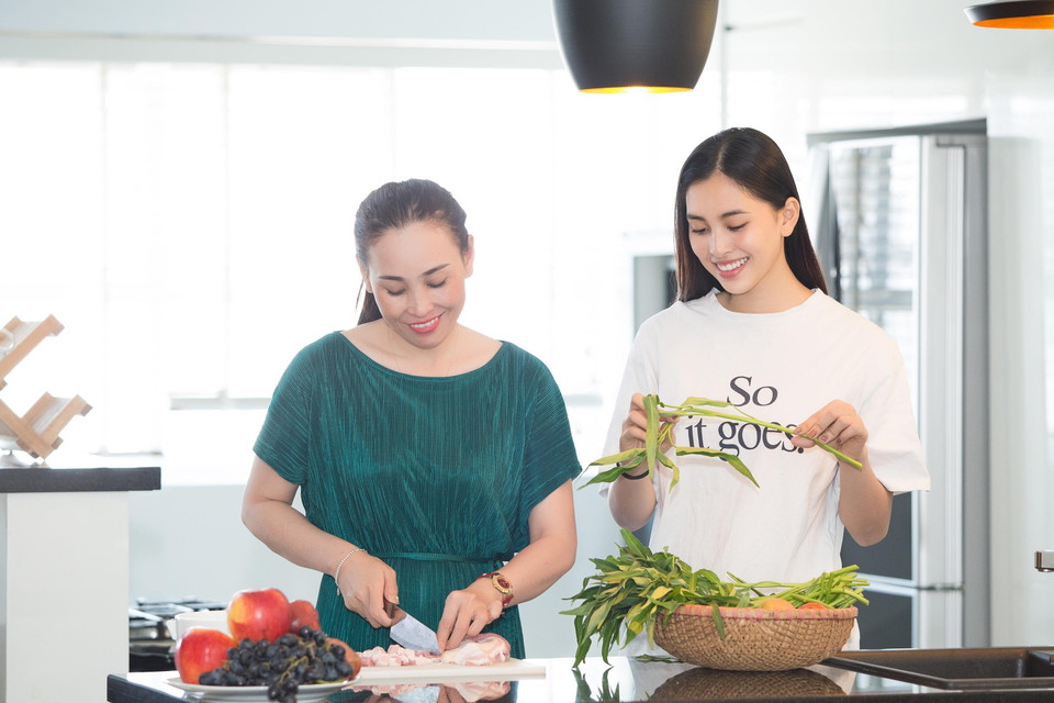 Nhân dịp mẹ vào thăm gần ngày Quốc tế Phụ nữ 8/3, Tiểu Vy đã có những giây phút nhí nhảnh và tình cảm cùng mẹ cùng nấu bữa ăn tại 'ngôi nhà Hoa hậu' – căn nhà được ban tổ chức cuộc thi Hoa hậu Việt Nam tài trợ khi cô gái Quảng Nam xa gia đình vào thành phố sau khi đăng quang. (Ảnh: Viết Quý/Vietnam+)