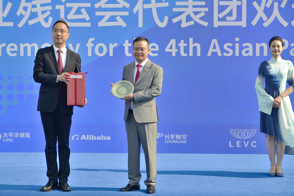 Thay mặt Đoàn Thể thao Việt Nam, Trưởng Đoàn Nguyễn Hồng Minh (giữa) tặng đại diện Ban tổ chức Asian Para Games 2023 bình gốm vẽ những thắng cảnh nổi tiếng của Việt Nam. (Ảnh: Vietnam+)