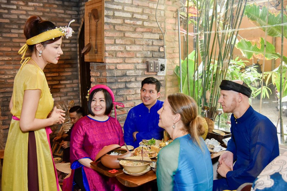 Các thực khách nghe giới thiệu về mâm cỗ ngày Tết của người Việt trước khi thưởng thức. (Ảnh: CTV/Vietnam+)