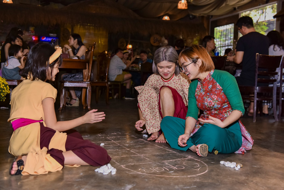 Chơi trò chơi dân gian ô ăn quan. (Ảnh: CTV/Vietnam+)