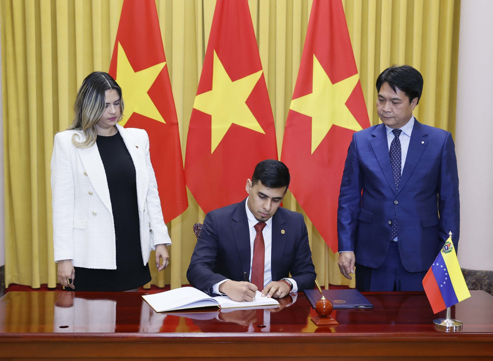 Đại sứ Venezuela Juan Carlos Fernandes Juarez viết lưu bút. (Ảnh: Thống Nhất/TTXVN)