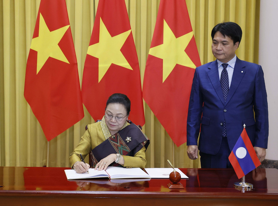 Đại sứ Cộng hòa Dân chủ Nhân dân Lào Khamphao Ernthavanh viết lưu bút. (Ảnh: Thống Nhất/TTXVN)