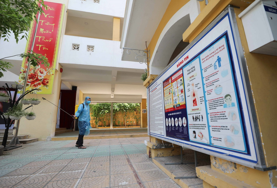 Phun khử khuẩn tại điểm thi Trường THPT Trần Nhân Tông, quận Hai Bà Trưng. (Ảnh: Thanh Tùng/TTXVN)