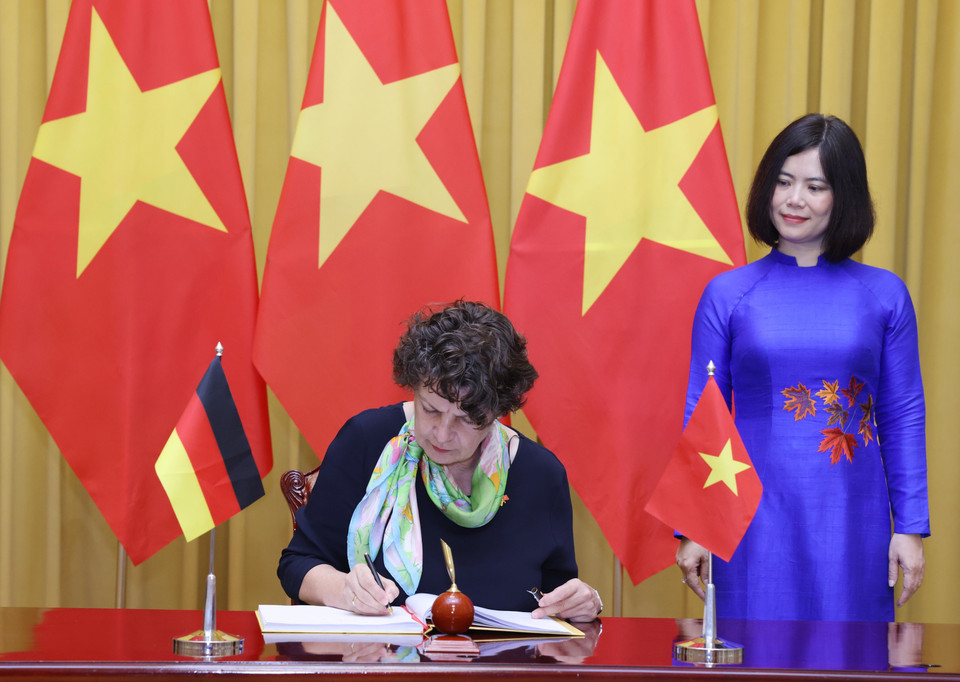 Đại sứ Cộng hòa Liên bang Đức tại Việt Nam Helga Margarete Barth ghi lưu bút. (Ảnh: Lâm Khánh/TTXVN)