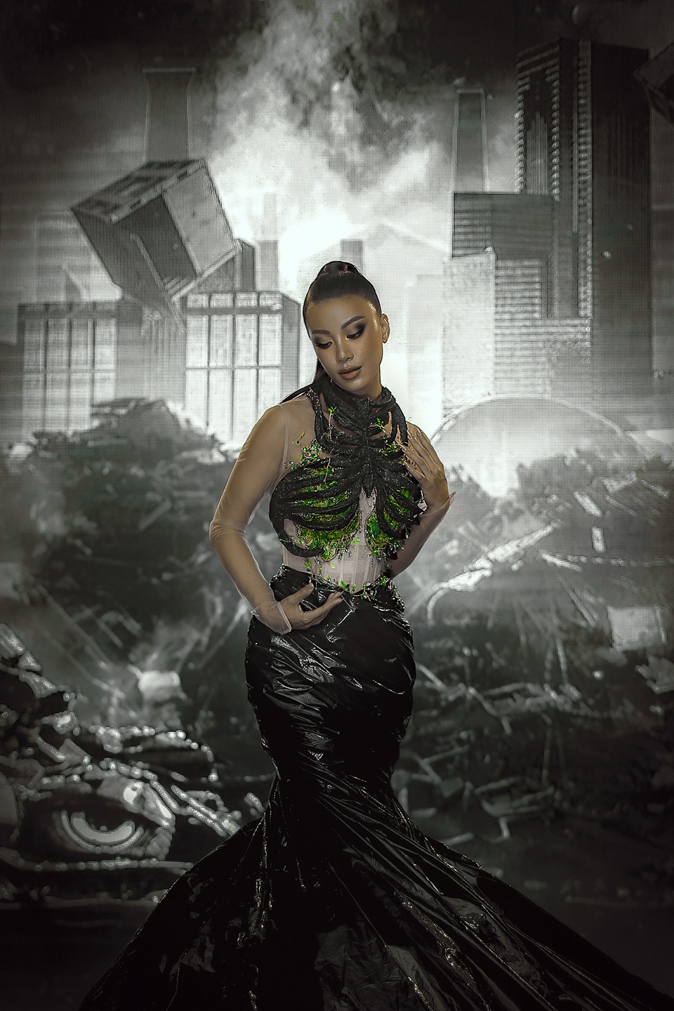 Thiết kế thứ hai với sắc đen chủ đạo lại thể hiện tinh thần bảo vệ lá phổi xanh của thế giới. Phần croptop làm bằng kỹ thuật 3D để dựng nên khung xương và điểm nhấn đặc biệt chính là phần ‘lá phổi xanh’ được đính kết bởi pha lê và những lá cây màu xanh từ bỏ chai nhựa. (Ảnh: CTV/Vietnam+)