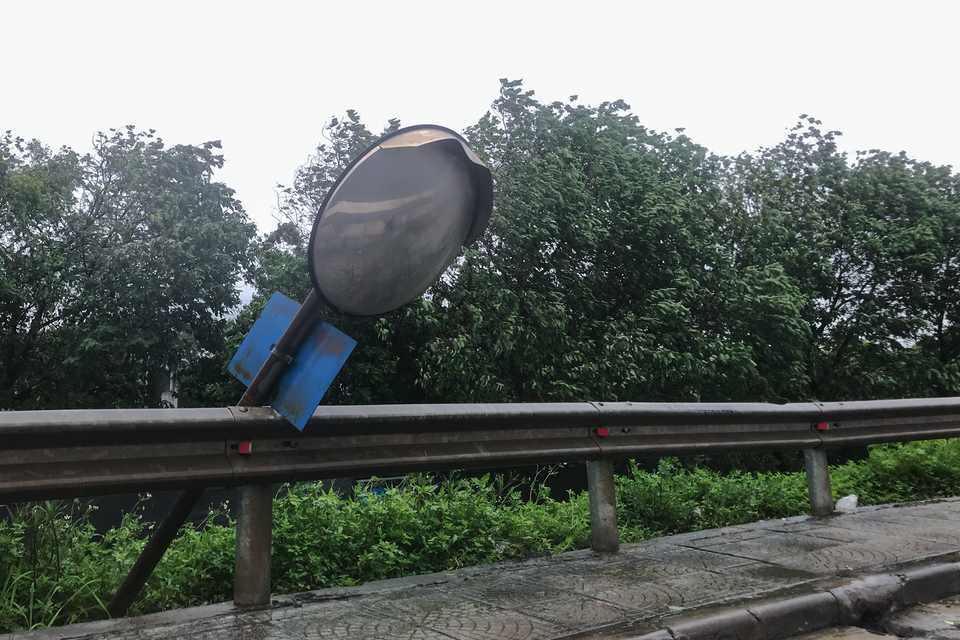 Cột gương cầu lồi tại các khúc cua cũng 'chao nghiêng' vì ảnh hưởng của siêu bão. (Ảnh: Việt Anh/Vietnam+)