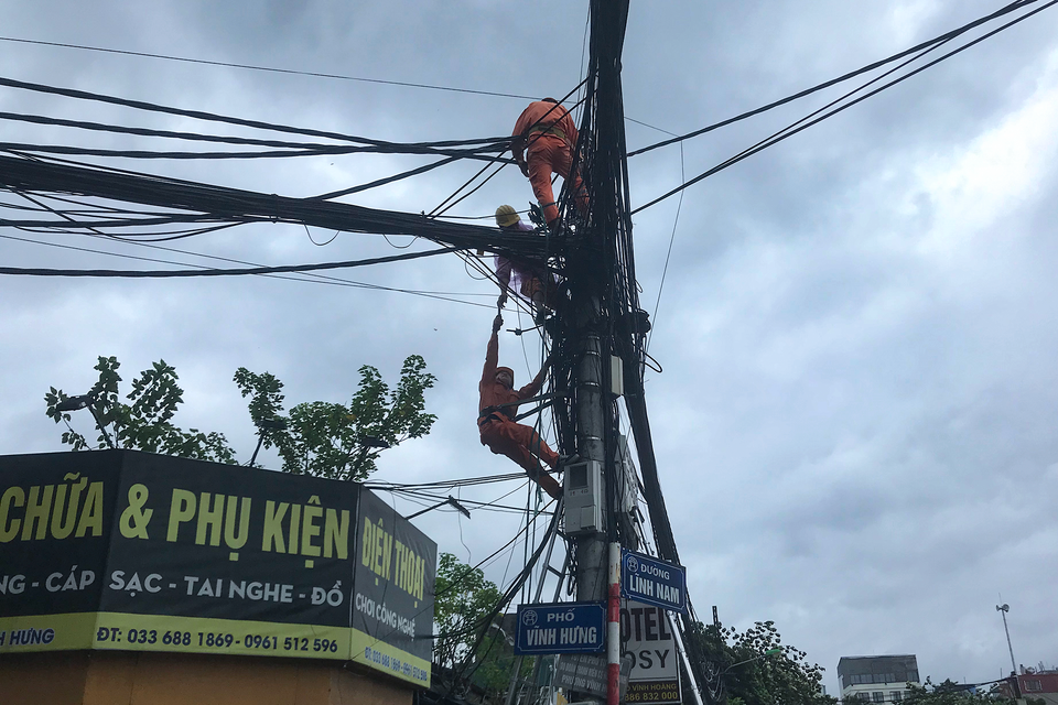 Lực lượng đơn vị điện lực nhanh chóng sửa chữa và khắc phục hậu quả. (Ảnh: Việt Anh/Vietnam+)