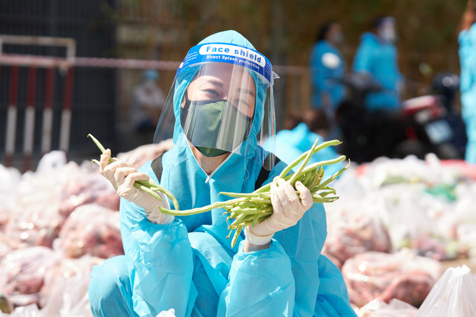 Hoa hậu Khánh Vân không chỉ vận động các mạnh thường quân mà còn trực tiếp tham gia hỗ trợ trao quà cho người dân giữa tâm dịch. (Ảnh: CTV/Vietnam+)