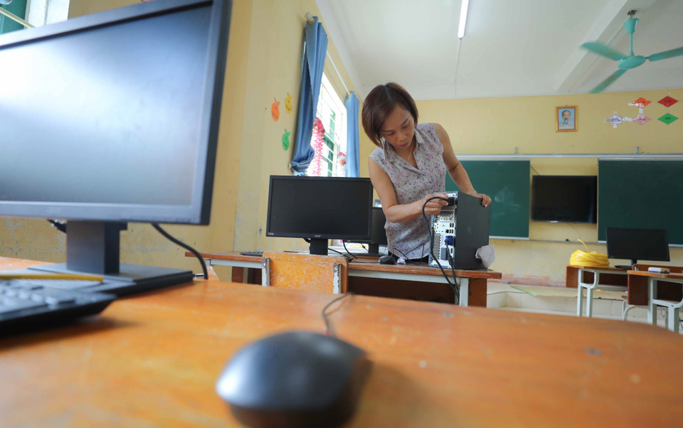 Giáo viên Trường Phổ thông Dân tộc Bán trú Tiểu học và Trung học Cơ sở Hồ Bốn (Mù Cang Chải, Yên Bái) lắp đặt máy tính được mượn từ một số đơn vị trên địa bàn kịp thời phục vụ cho năm học mới. (Ảnh: Thanh Tùng/TTXVN)