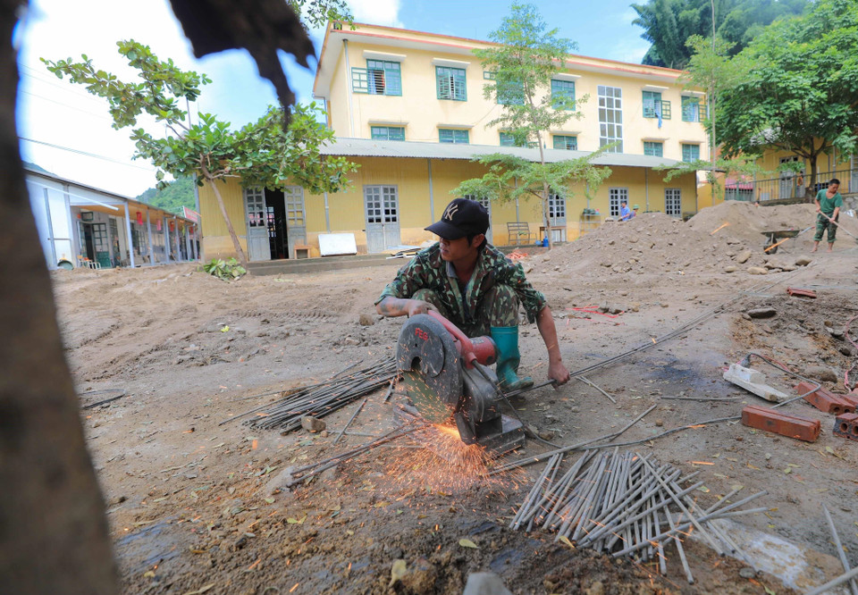 Công tác khắc phục hậu quả mưa lũ tại trường. (Ảnh: Thanh Tùng/TTXVN)
