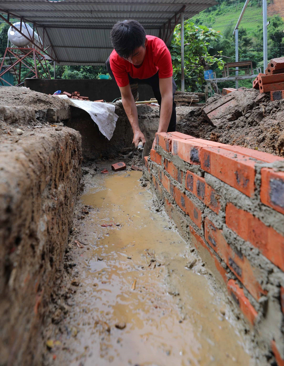 Khắc phục hậu quả mưa lũ tại trường. (Ảnh: Thanh Tùng/TTXVN)