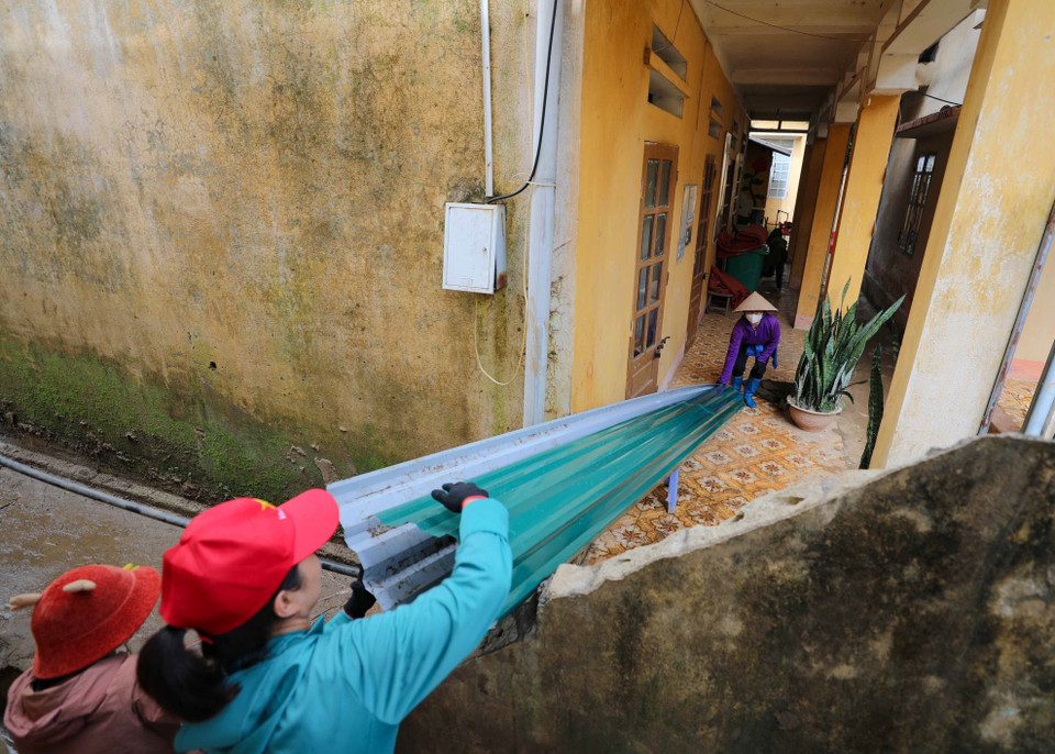 Giáo viên cùng các lực lượng trợ giúp đang khẩn trương dọn dẹp, sửa chữa trường, lớp để học sinh có thể đón năm học mới đúng kế hoạch. (Ảnh: Thanh Tùng/TTXVN)