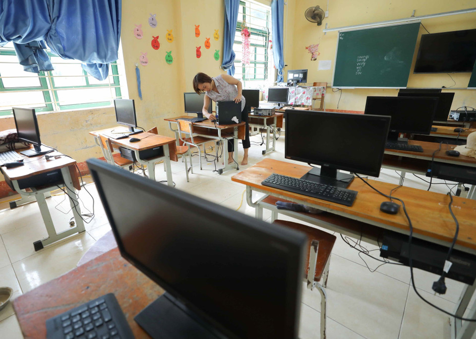 Giáo viên lắp đặt máy tính được mượn từ một số đơn vị trên địa bàn kịp thời phục vụ cho năm học mới. (Ảnh: Thanh Tùng/TTXVN)