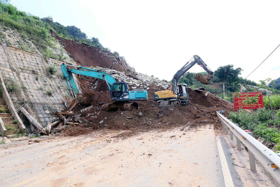 Máy xúc, ô tô được huy động để xúc, ủi, san gạt đảm bảo thông tuyến nhanh nhất. (Ảnh: Quang Quyết/TTXVN)