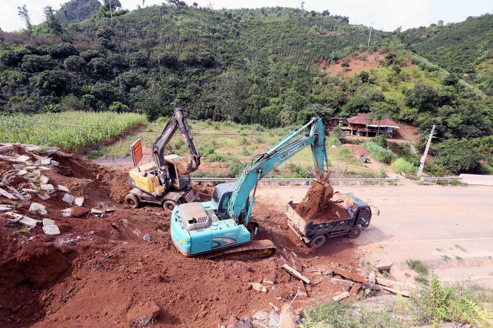 Máy xúc, ôtô được huy động để xúc, ủi, san gạt đảm bảo thông tuyến nhanh nhất. (Ảnh: Quang Quyết/TTXVN)