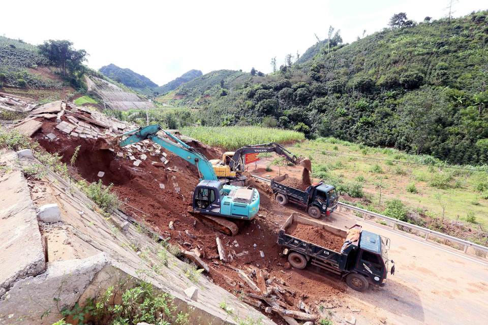 Máy xúc, ô tô được huy động để xúc, ủi, san gạt đảm bảo thông tuyến nhanh nhất. (Ảnh: Quang Quyết/TTXVN)
