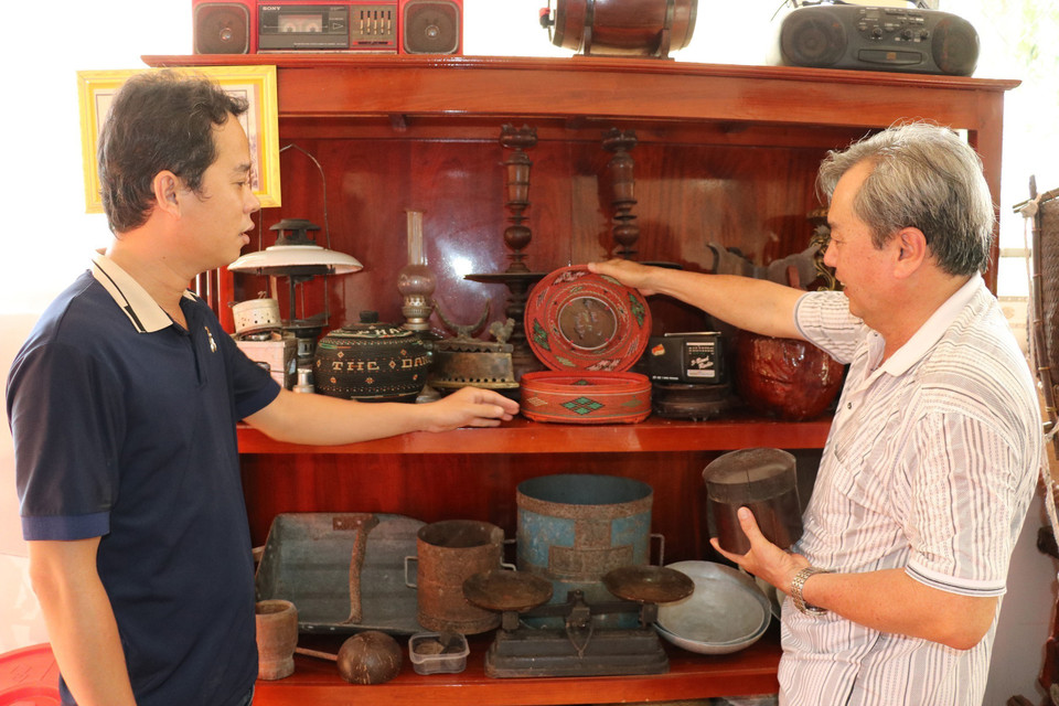 Ông Cao Tấn Hiệu (phải) giới thiệu giỏ đựng trầu do tổ tiên truyền lại. (Ảnh: Hữu Chí /TTXVN)