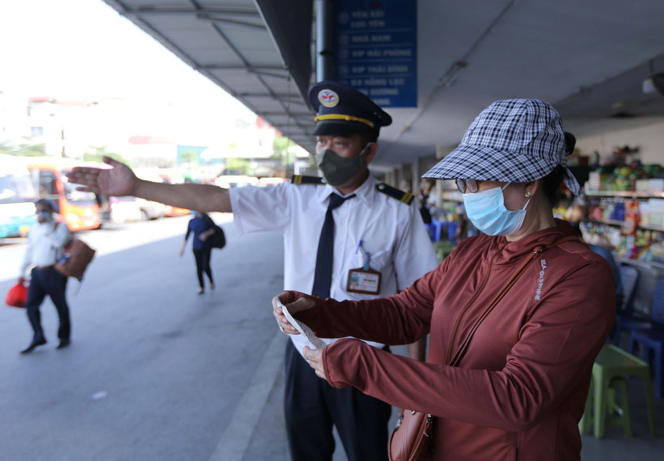 Hành khách đi xe và nhân viên tại bến xe Gia Lâm chấp hành nghiêm việc đeo khẩu trang. (Ảnh: Hoàng Hiếu/TTXVN)