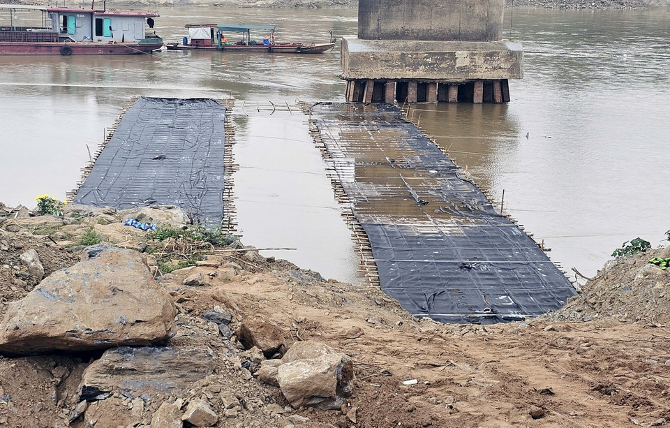 Phía dưới cầu Phong Châu bị sập, cơ quan chức năng đã làm xong đường công vụ, sẵn sàng cho việc phá dỡ trụ, nhịp cầu còn lại. (Ảnh: Tạ Toàn/TTXVN)