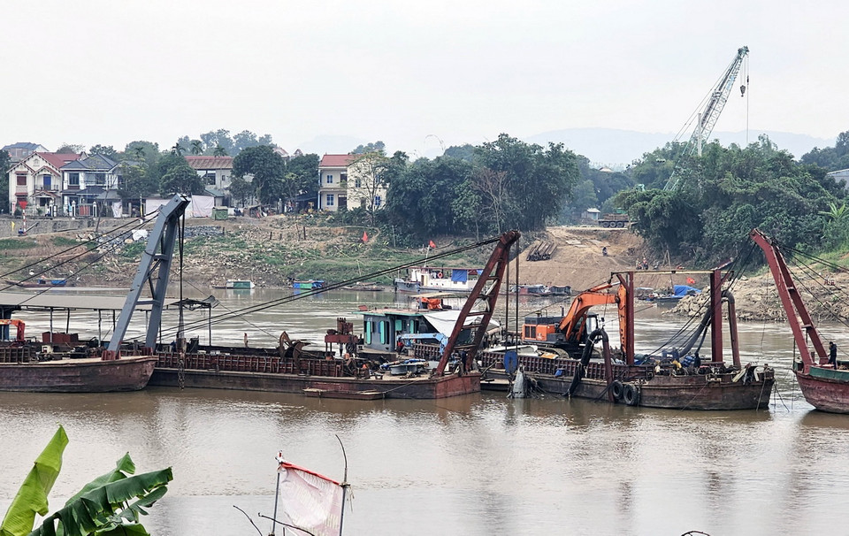 Dưới lòng sông, các cơ quan chức năng tiếp tục trục với các trụ cầu bị sập. (Ảnh: Tạ Toàn/TTXVN)