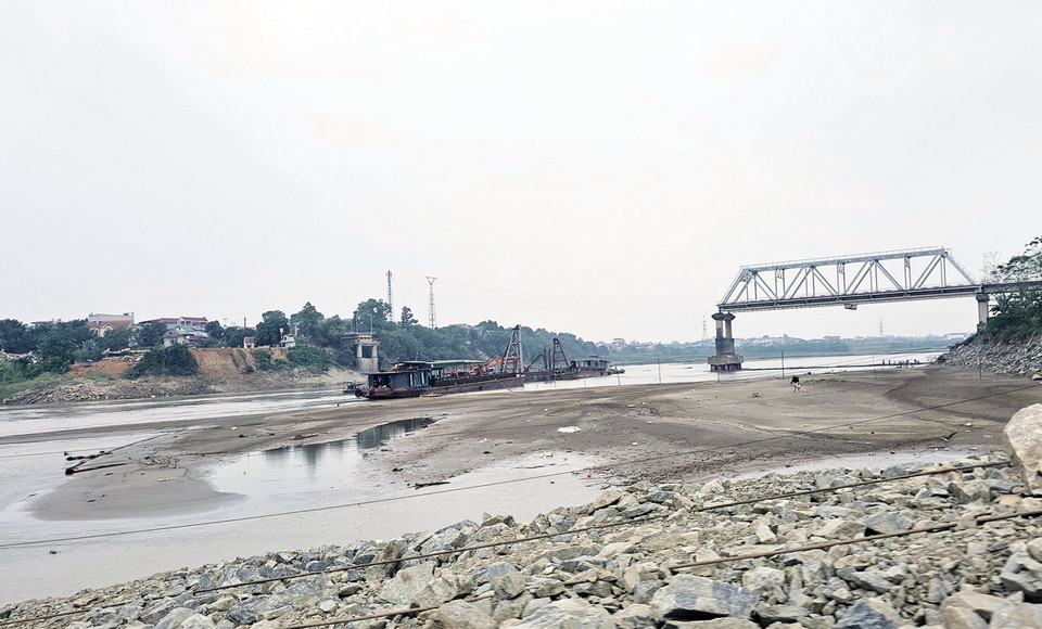 Mực nước tại khu vực cầu Phong Châu đang xuống thấp, cồn cát nổi lên dưới đoạn cầu cũ, thuận lợi cho cơ quan chức năng tiến hành phá dỡ các trụ, nhịp cầu Phong Châu bị sập. (Ảnh: Tạ Toàn/TTXVN)