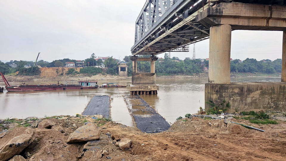 Phía dưới nhịp cầu Phong Châu bị sập, cơ quan chức năng đã làm xong đường công vụ sẵn sàng cho việc phá dỡ trụ, nhịp cầu còn lại. (Ảnh: Tạ Toàn/TTXVN)