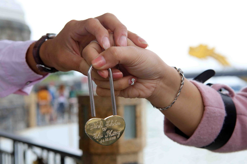  Nơi đây thu hút đông đảo người dân và khách du lịch đến tham quan chụp ảnh, đặc biệt là các cặp đôi ghi dấu tình yêu bằng những 'ổ khóa trái tim' khóa vào thành cầu. (Ảnh: Trần Lê Lâm/TTXVN)