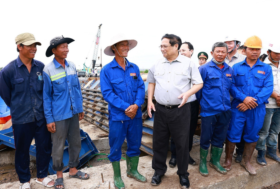 Thủ tướng Phạm Minh Chính với công nhân thi công Dự án Cao tốc Châu Đốc-Cần Thơ-Sóc Trăng. (Ảnh: Dương Giang/TTXVN)