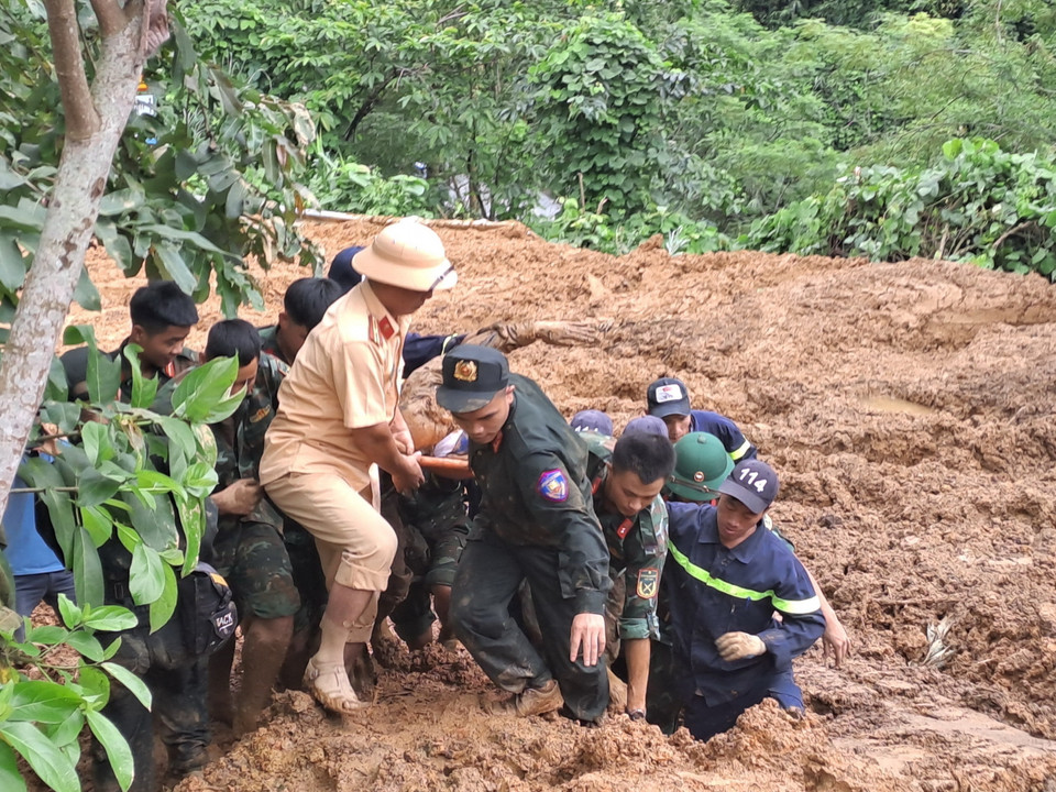 Các lực lượng tìm kiếm đưa thi thể nạn nhân thứ 8 bị vùi lấp ra khỏi khu vực sạt lở. (Ảnh: Đức Thọ/TTXVN)
