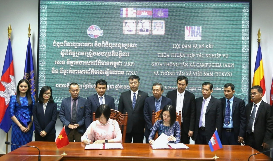 Tổng Giám đốc TTXVN Vũ Việt Trang (bên trái) và Tổng Giám đốc AKP Sokmom Nimul ký kết thỏa thuận hợp tác nghiệp vụ giai đoạn mới giữa hai hãng thông tấn quốc gia. (Ảnh: Hoàng Minh/TTXVN)