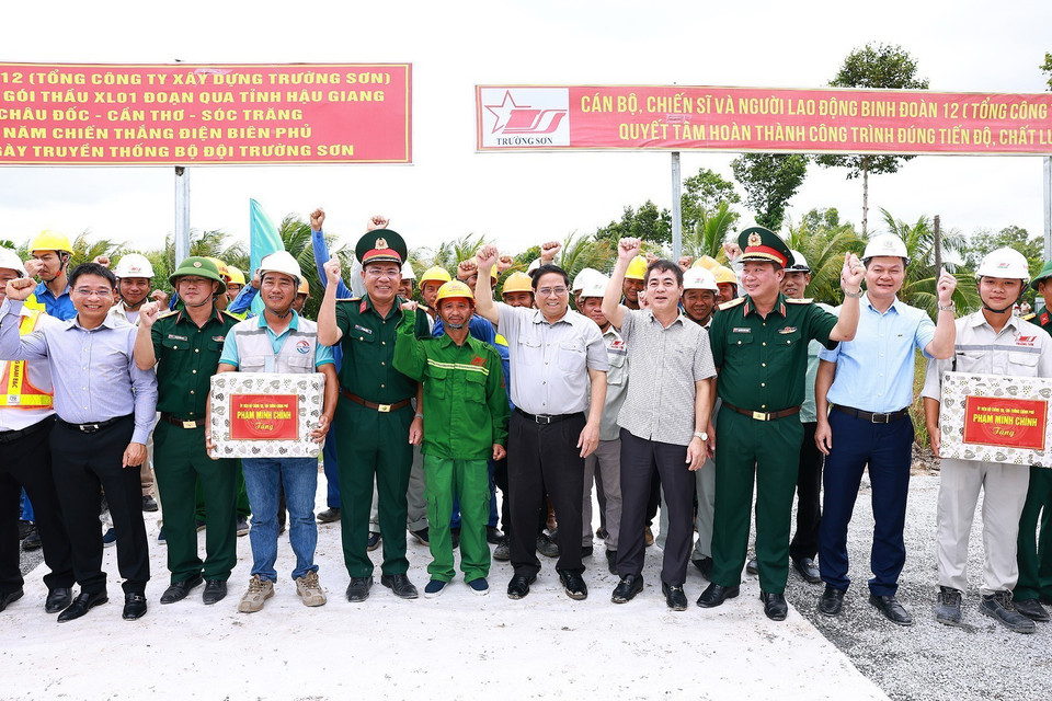 Thủ tướng Phạm Minh Chính với công nhân thi công Dự án Cao tốc Châu Đốc-Cần Thơ-Sóc Trăng. (Ảnh: Dương Giang/TTXVN)
