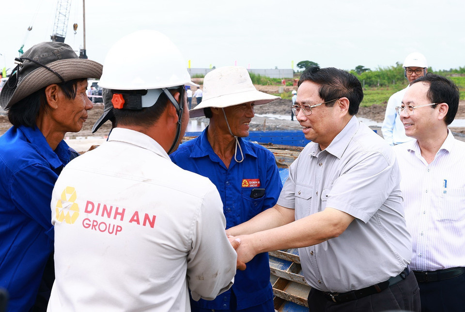 Thủ tướng Phạm Minh Chính với công nhân thi công Dự án Cao tốc Châu Đốc-Cần Thơ-Sóc Trăng. (Ảnh: Dương Giang/TTXVN)