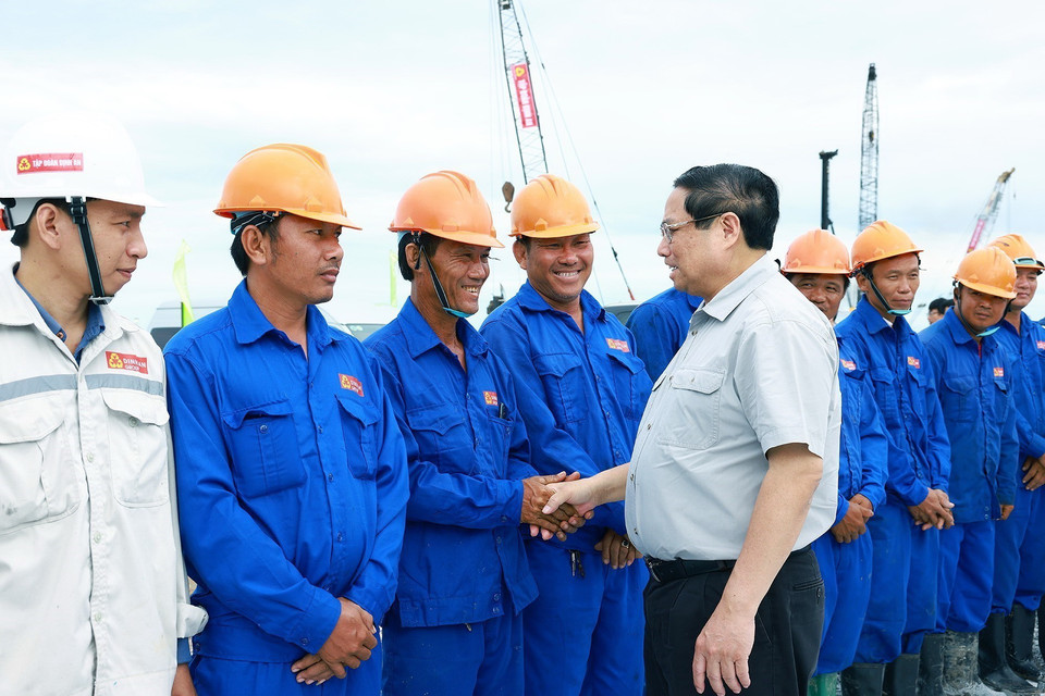 Thủ tướng Phạm Minh Chính với công nhân thi công tại Nút giao Lộ Tẻ-Rạch Sỏi, xã Thạnh Tiến, huyện Vĩnh Thạnh, Cần Thơ. (Ảnh: Dương Giang/TTXVN)