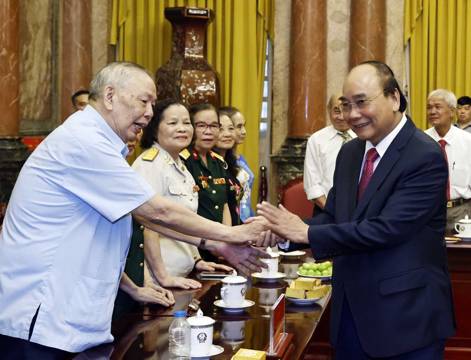 Chủ tịch nước và các cán bộ từng trực tiếp phục vụ và bảo vệ Bác Hồ. (Ảnh: Thống Nhất/TTXVN)