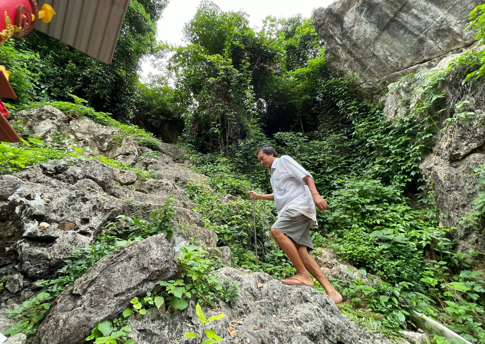 Hàng ngày, người quản lý khu di tích là ông Bùi Văn Nhàng mặc dù chân đau nhưng vẫn chống gậy lên chăm nom khu đền thượng. (Ảnh: Xuân Mai/Vietnam+)