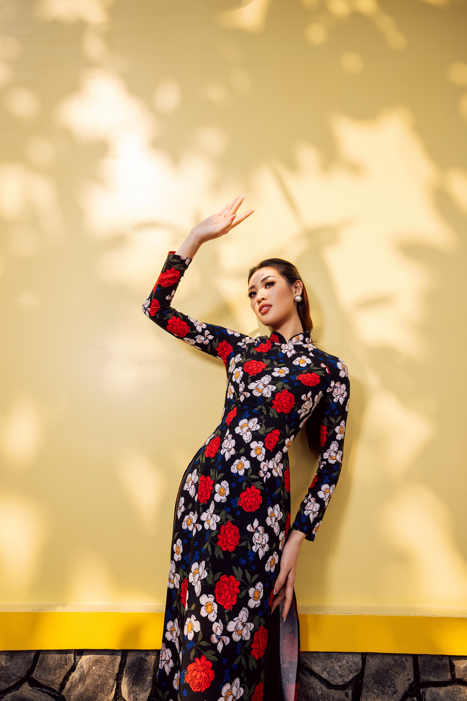 Ở bối cảnh đầu tiên tại bến phà, Hoa hậu Khánh Vân chọn áo dài màu đen họa tiết hoa nhí, kết hợp kiểu tóc gợi nhớ đến hình ảnh những quý cô thành thị phồn hoa xưa. (Ảnh: CTV/Vietnam+)