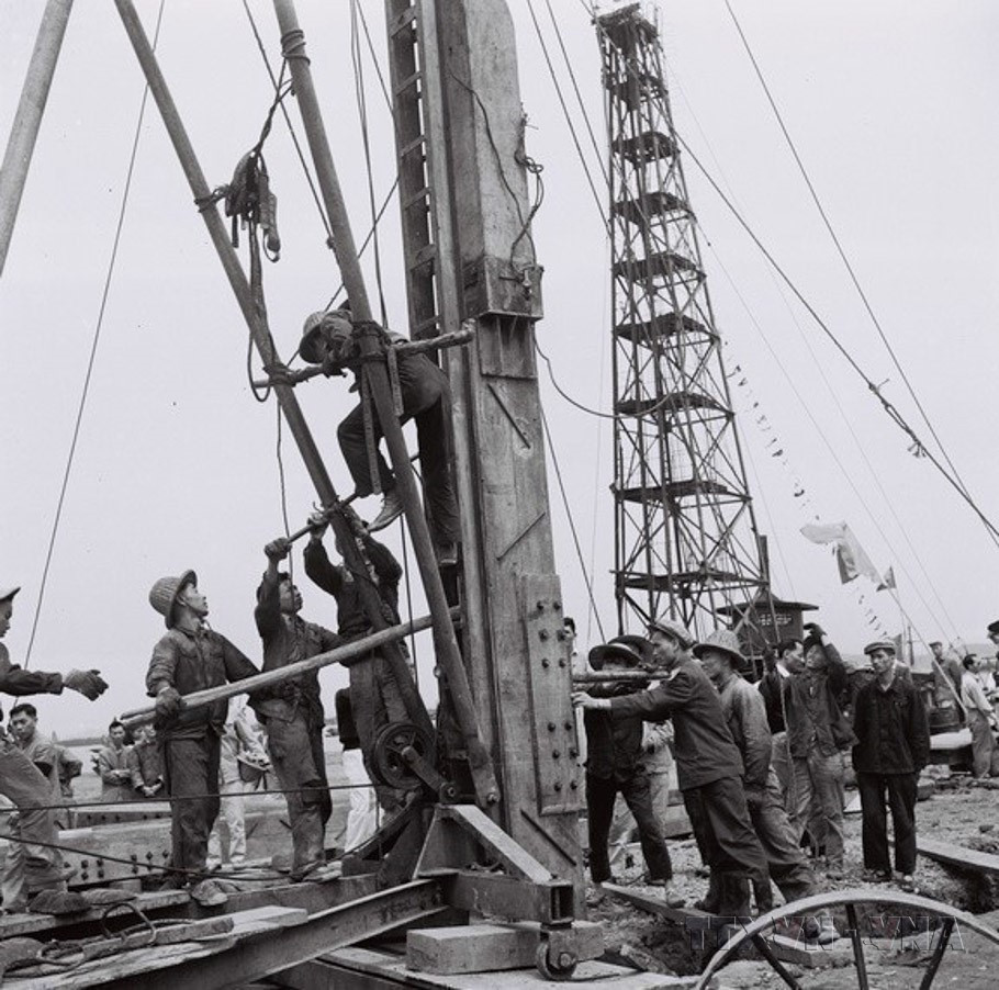 Công nhân kỹ thuật Trung Quốc và Việt Nam điều khiển máy đóng cọc để làm đê quai xanh chắn nước trong thi công xây dựng triền tàu Nhà máy Đóng tàu Hải Phòng (1960). (Ảnh: Lâm Hồng/TTXVN)