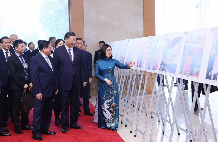 Phó Tổng Giám đốc TTXVN Đoàn Thị Tuyết Nhung giới thiệu với Thủ tướng Phạm Minh Chính và Tổng Bí thư, Chủ tịch Trung Quốc Tập Cận Bình những hình ảnh tiêu biểu về quan hệ hai nước, do Thông tấn xã Việt Nam thực hiện (13/12/2023). (Ảnh: Dương Giang/TTXVN)