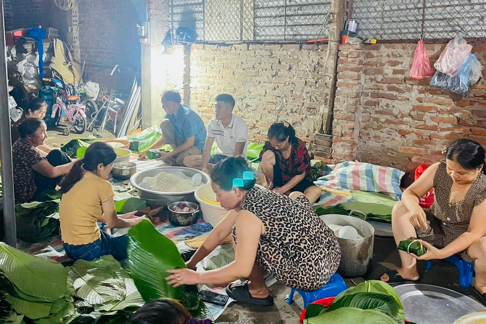 Bà con làng La Phù tập trung tại hộ gia đình nhà cô Bình Sơn (xóm Trần Phú) để gói bánh chưng. (Ảnh: Việt Anh/Vietnam+)