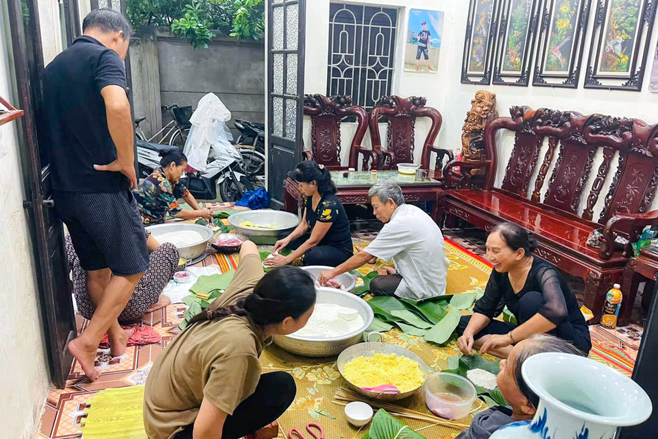 Dân làng La Phù mỗi người một việc, người xếp lá tạo khuôn, người xếp nhân gói bánh để sớm hoàn thành công việc. (Ảnh: Việt Anh/Vietnam+)